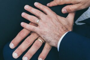 This is an image from the Gay Therapist in Washington DC page of the website of two men's hands on top of each other while proudly wearing wedding rings.