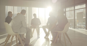 This image is for Dr. Heilman's Interpersonal Psychotherapy Group for Gay Men in Washington DC website page, and shows a backlit Image of a Men's Therapy Group